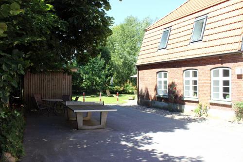 a picnic table in front of a brick building at OSTSEEferien am BARFUSSpark in Hasselberg