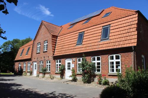 a brick building with an orange roof at OSTSEEferien am BARFUSSpark in Hasselberg