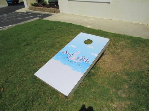a white board with a picture of a seahorse on the grass at Surf Side Hotel in Nags Head