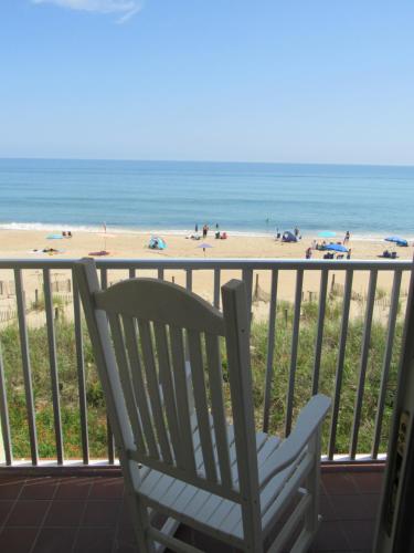 a chair sitting on a balcony overlooking the beach at Surf Side Hotel in Nags Head