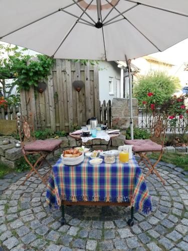 une table avec une assiette de nourriture et un parapluie dans l'établissement Sweet Home Suite, à Hallerndorf