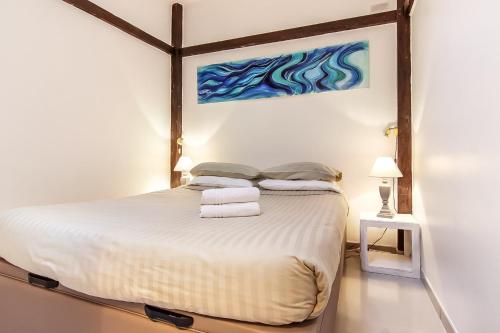 Schlafzimmer mit einem Bett mit Wandgemälde in der Unterkunft Bijou Apartment in Safranier - Old Town Antibes in Antibes