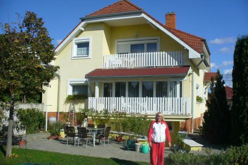 a woman standing in front of a house at Györgyi Haus in Bük