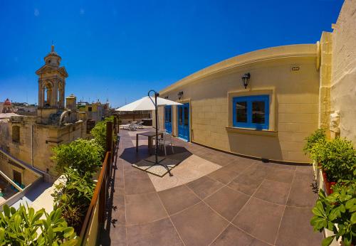 a building with a balcony with a clock tower at Casa Azzopardi Suites in Rabat