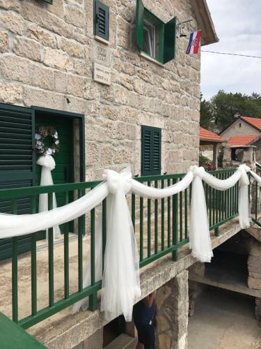 a fence with a white bow on a building at Apartman Studio Zdravko Eco Village in Imotski
