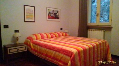 ペルージャにあるCharming Apartment Perugiaのベッドルーム1室(オレンジと黄色のストライプの毛布付きのベッド1台付)