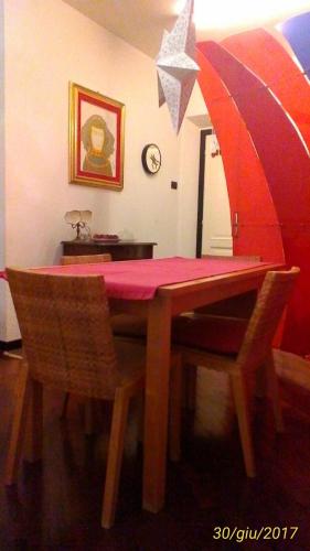 ペルージャにあるCharming Apartment Perugiaの木製テーブル(赤いテーブルクロス、傘付)