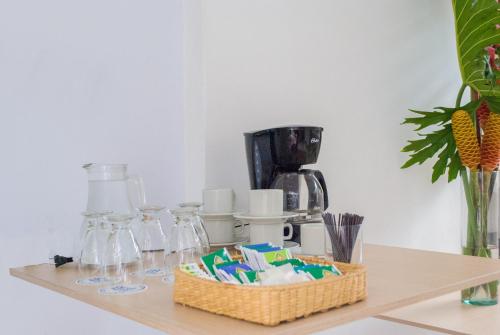 a counter with a coffee maker and a shelf with glasses at Hotel Casa Santa Monica Norte in Cali