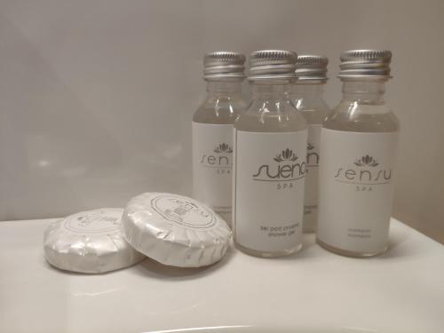 a group of four bottles of liquid sitting on a shelf at H33 Apartamenty in Bytom