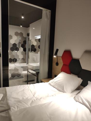 a bedroom with a bed and a bathroom with a mirror at H33 Apartamenty in Bytom