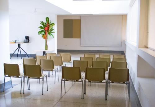 a group of chairs in a room with a screen at Hotel Casa Santa Monica Norte in Cali