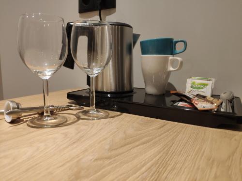 two wine glasses sitting on top of a table at H33 Apartamenty in Bytom