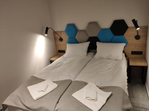 a large bed with two white towels on it at H33 Apartamenty in Bytom
