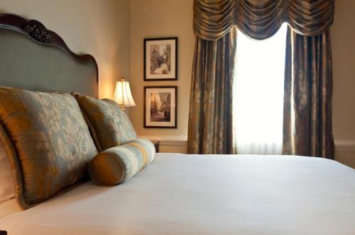 
a bed with a white comforter and a large window at French Market Inn in New Orleans

