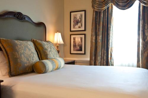 a bedroom with a bed with pillows and a window at French Market Inn in New Orleans