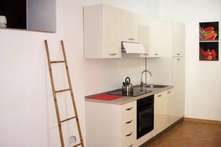 een keuken met witte kasten en een ladder erin bij Monolocale Ristrutturato in Pizzo