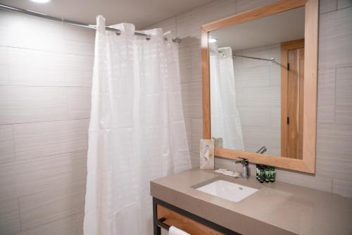 a bathroom with a white shower curtain and a sink at Tunnel Mountain Resort in Banff