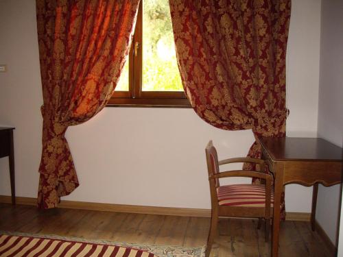 a desk and a chair in front of a window at Agriturismo Il Borgo Degli Ulivi in Roseto degli Abruzzi