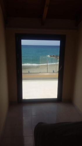 a window in a room with a view of the ocean at Platanias Aetheras Beach in Plataniás