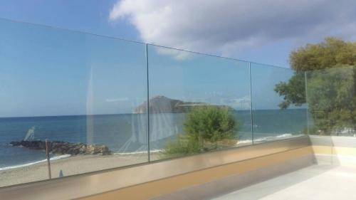 a view of the ocean from a room with glass at Platanias Aetheras Beach in Plataniás