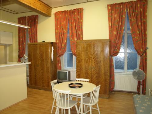 a living room with a table and chairs and a tv at Pension Gross in Vienna