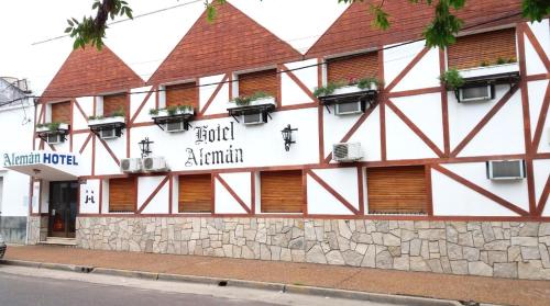 a white building with windows and plants on it at Hotel Alemán in Gualeguaychú