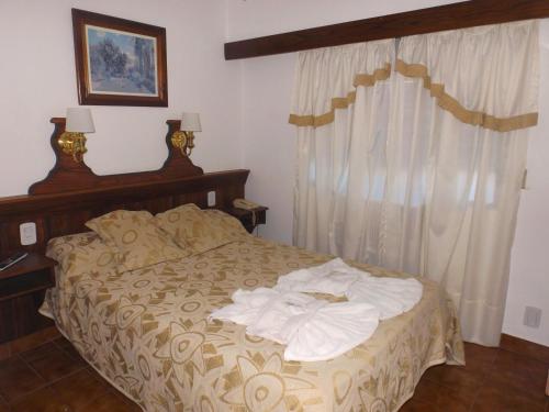 a bedroom with a bed with towels on it at Hotel Alemán in Gualeguaychú