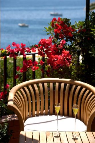 a wooden bench with two glasses of wine at Taverna Del Capitano in Massa Lubrense