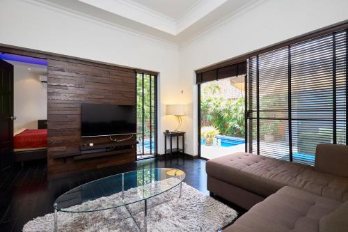 a living room with a couch and a tv at VIEW TALAY VILLAs POOL 60, JOMTIEN BEACH, PATTAYA in Jomtien Beach