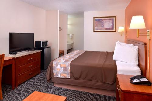 a hotel room with a bed and a flat screen tv at Americas Best Value Inn Sullivan in Sullivan