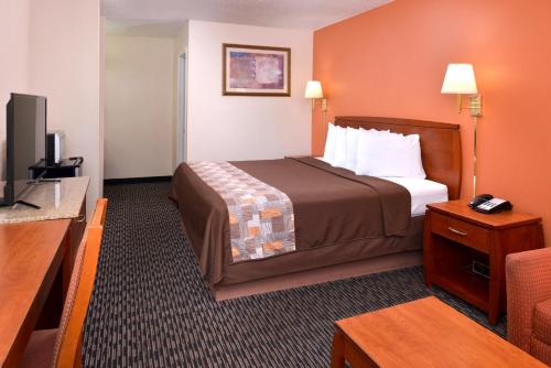 a hotel room with a bed and a television at Americas Best Value Inn Sullivan in Sullivan
