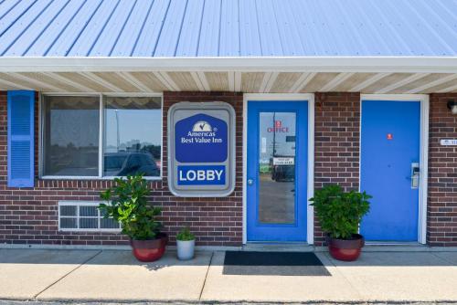 a brick building with a blue door and a lobby at Americas Best Value Inn Sullivan in Sullivan