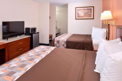 a hotel room with two beds and a flat screen tv at Americas Best Value Inn Sullivan in Sullivan