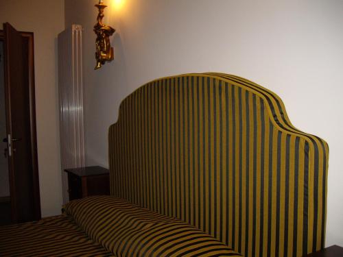 a green and white striped chair in a room at Agriturismo Il Borgo Degli Ulivi in Roseto degli Abruzzi