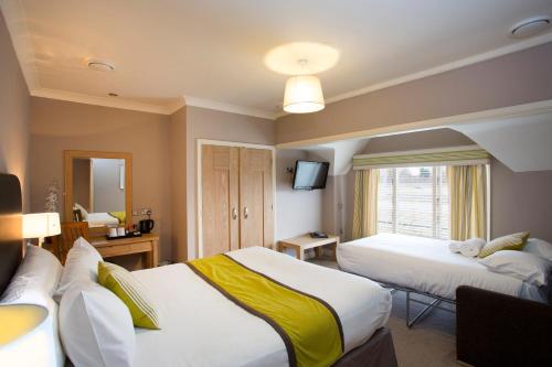 um quarto de hotel com duas camas e uma janela em Breckland Lodge em Attleborough
