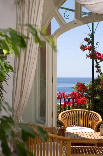 a porch with chairs and a view of the ocean at Taverna Del Capitano in Massa Lubrense