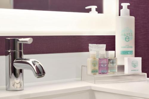 un lavabo con jabón y otros productos. en Coast Edmonton Plaza Hotel by APA, en Edmonton