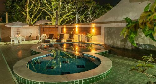 a swimming pool in a backyard at night at Pousada Lua e Mar in Ilhéus
