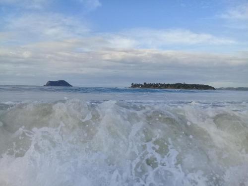 a body of water with an island in the distance at Morada do Sol Guest House in Búzios