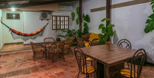 a dining room with a wooden table and chairs at Pousada Lua e Mar in Ilhéus