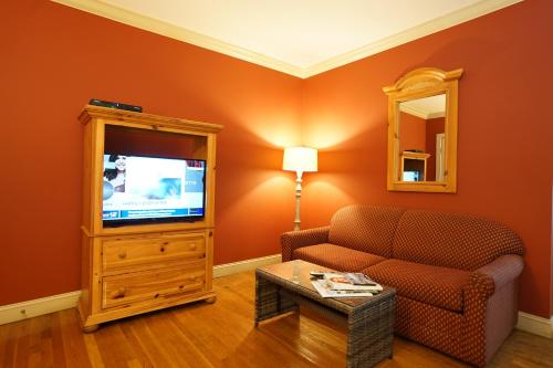 a living room with a couch and a tv at Southampton Long Island Hotel in Southampton
