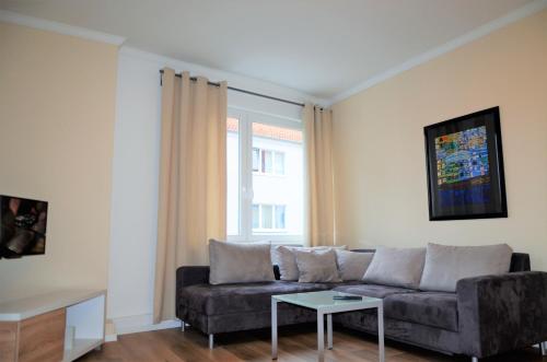 una sala de estar con un sofá y una mesa en Moderne Appartement Hannover Centrum - City Flat HbF, en Hannover