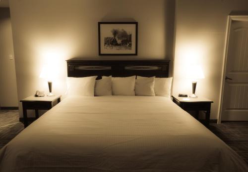a bedroom with a large white bed with two lamps at Days Inn by Wyndham Surrey in Surrey