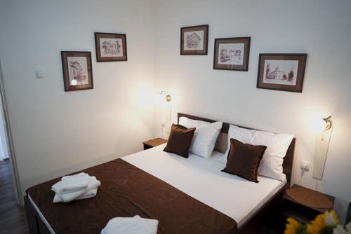 a bedroom with a bed with three pictures on the wall at Apartments & Dream Rooms in Niš