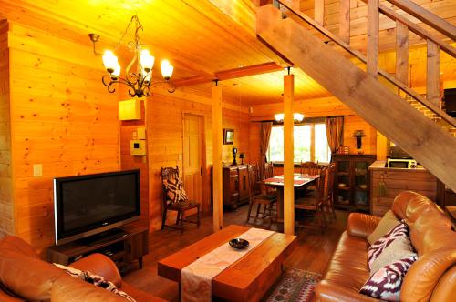 a living room with a couch and a tv in a cabin at YU・CABIN in Inawashiro