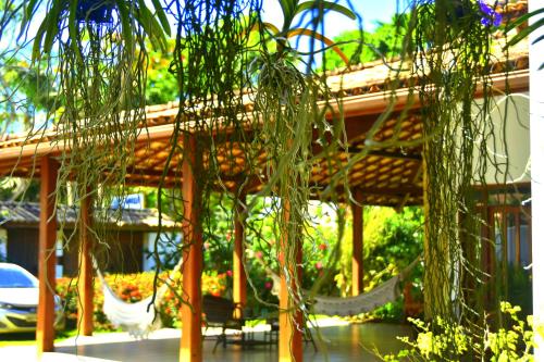 a gazebo with a hammock and some plants at Pousada Lua e Mar in Ilhéus