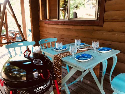 a table and a grill on a porch with a table and chairs at YU・CABIN in Inawashiro
