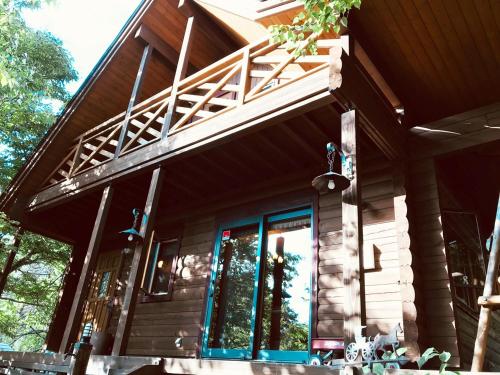 a wooden house with a balcony on top of it at YU・CABIN in Inawashiro
