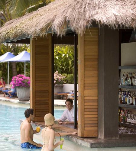 a group of people sitting around a bar in a swimming pool at Palm Cove Paradise - Couples spa beach getaway in Palm Cove