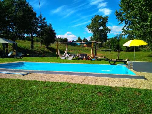 a swimming pool in a yard with an umbrella at Village Minhoure in Felgueiras